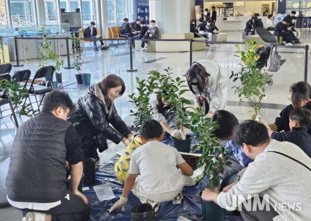 미래세대와 함께하는 ‘나는야 똑똑한 도시농부’ 교육현장(체험학습 참여가족이 우리나라에서 개발하고 보호등록된 감귤품종의 묘목을 심어보고 있다.)