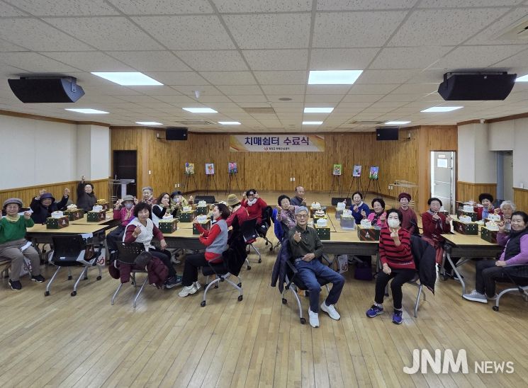 2025년 치매 쉼터 프로그램 수료식에 참여한 어르신, 보호자, 직원들이 기념촬영을 하고 있다.