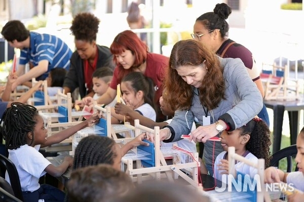 Brazilian kids learning how to weave during the exhibition